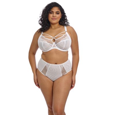 BRIANNA_WHITE_UW-PLUNGE-BRA_EL8080_FULL-BRIEF_EL8085_F_TRADE_3000_SS25 Kobieta o pełnych kształtach w białym komplecie: biustonosz z fiszbinami z paseczkami na dekolcie i wysokie figi z siateczki