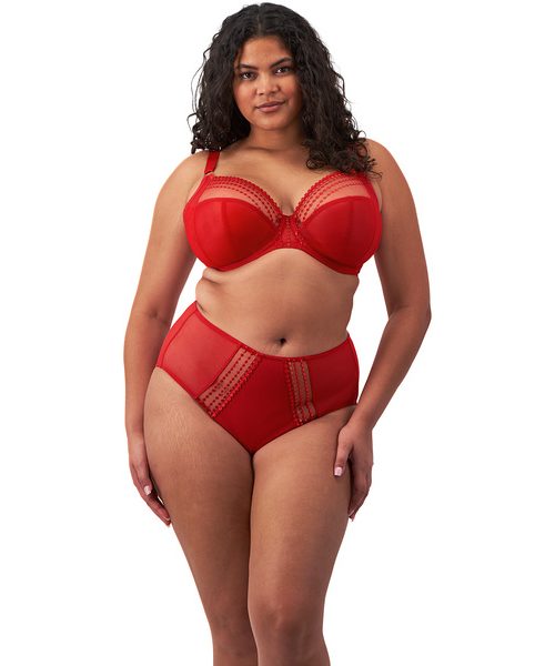 MATILDA-HAUTE_RED-UW_PLUNGE_BRA-EL8900-FULL_BRIEF-EL8906-F-TRADE-3000-AW24 Kobieta o pełnych kształtach w czerwonym komplecie: biustonosz z fiszbinami i majtki z wysokim stanem