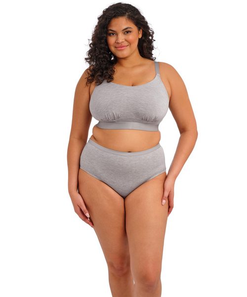 DOWNTIME_GREY-MARL_NON-WIRED-BRALETTE_EL301417_SHORT_EL301480_F _TRADE_3000_SS26 Kobieta o pełnych kształtach w szarym bawełnianym komplecie: miękki biustonosz i majtki z wysokim stanem