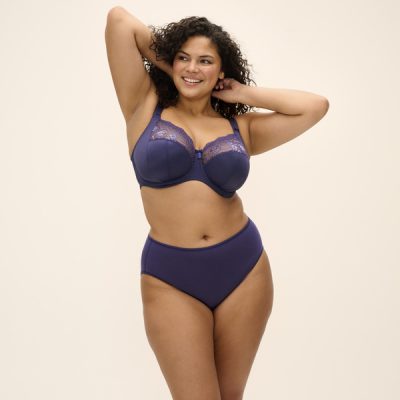 MORGAN_MIDNIGHT_UW-BRA_EL4111_SMOOTH_FULL-BRIEF_EL4565_F1_TRADE_3000 Kobieta o pełnych kształtach w granatowym komplecie: biustonosz z fiszbinami z haftem u góry miseczek i wysokie figi